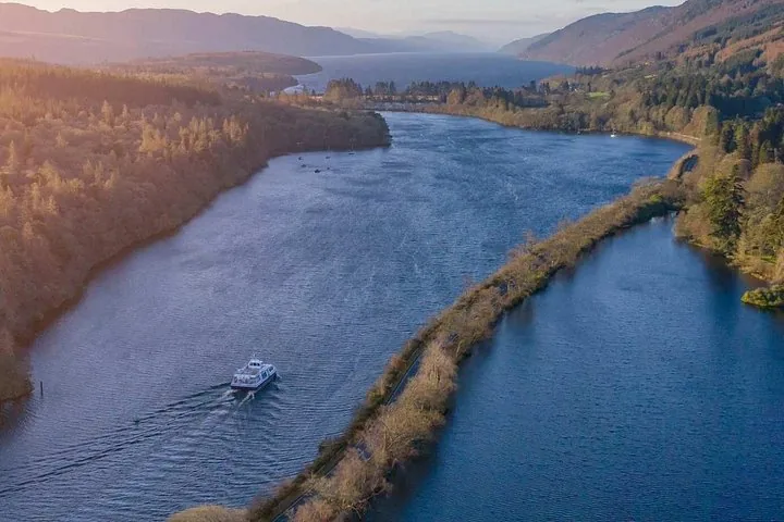 Aerial view of a boat traveling along a canal surrounded by nature.